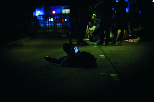 躺在街道上刷手机的学生